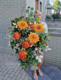 A large tombstone with red and orange chrysanthemum