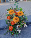 A large tombstone with red and orange chrysanthemum