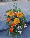 A large tombstone with red and orange chrysanthemum