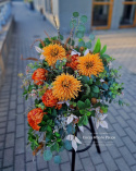 A large tombstone with red and orange chrysanthemum