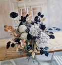 Tombstone decoration in a basket with black poppies and hydrangea and artichokes